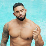 a man without a shirt on a cell phone