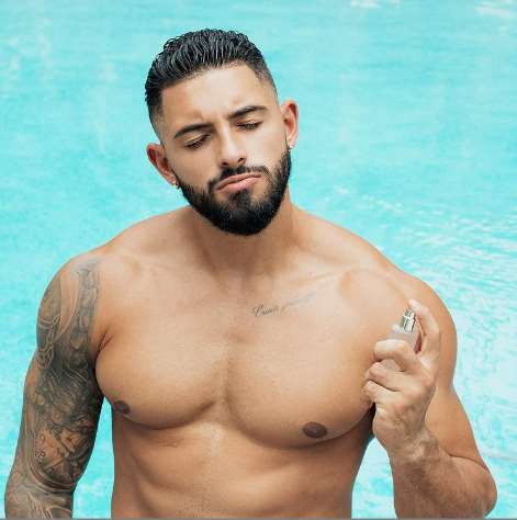 a man without a shirt on a cell phone